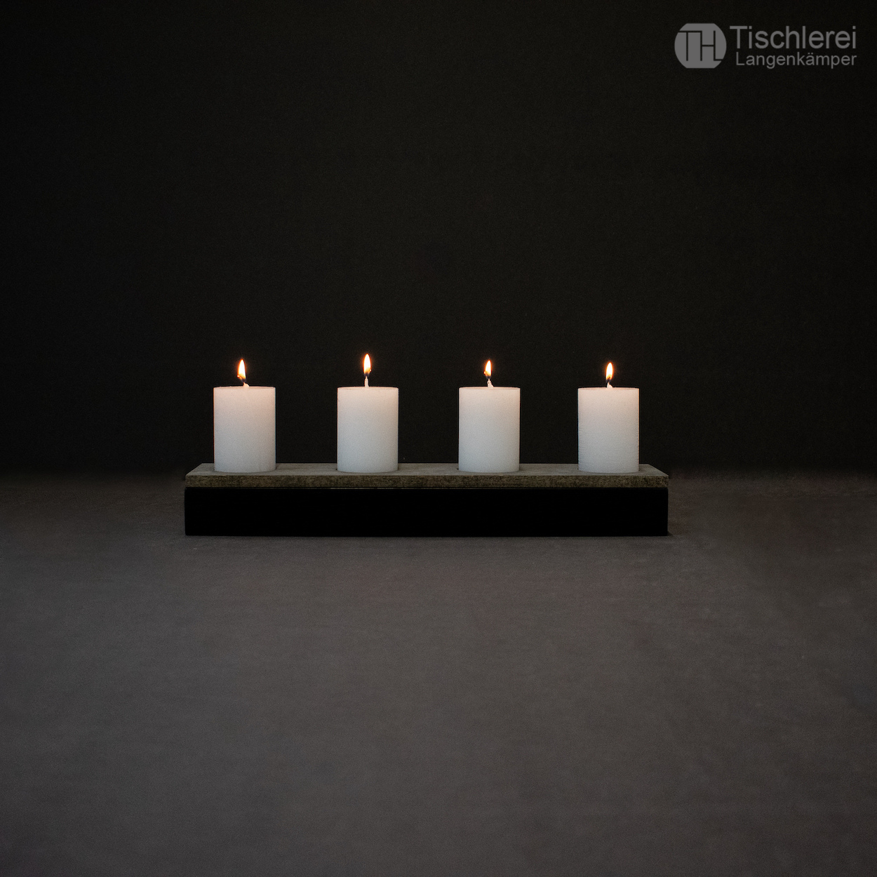 Frontale Ansicht Adventskranz aus Eiche (schwarz lackiert) mit brennenden Kerzen